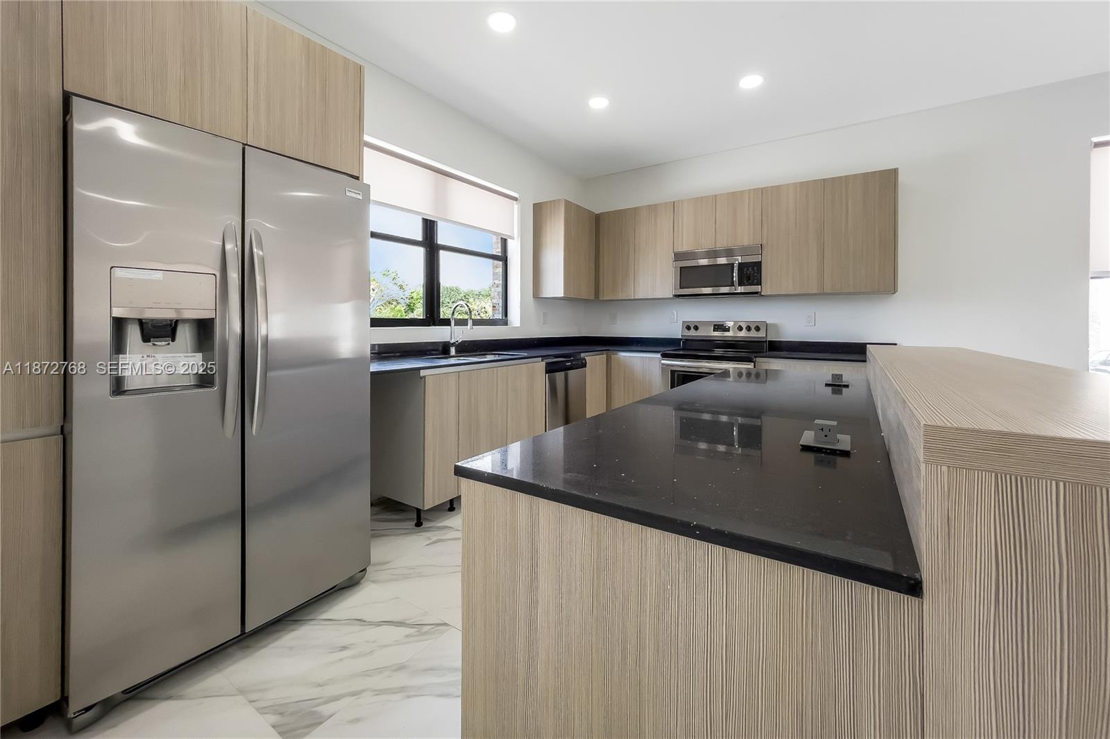 6159 Southwest 36th Court Miramar, FL 33023 - Photo 6 of 28 a kitchen with stainless steel appliances granite countertop a sink a stove and a refrigerator