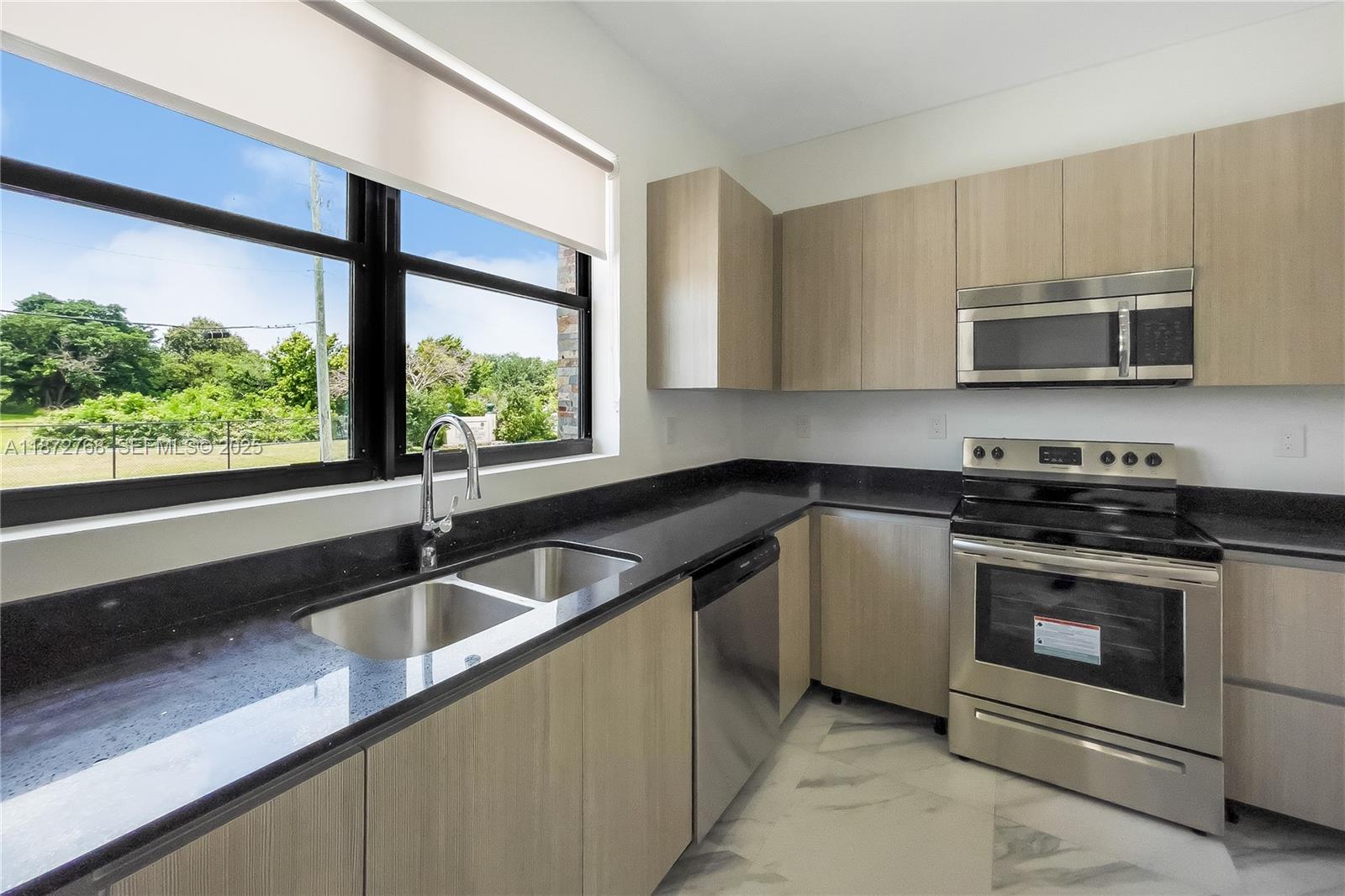 6159 Southwest 36th Court Miramar, FL 33023 - Photo 8 of 28 a kitchen with stainless steel appliances granite countertop a sink a stove a microwave and wooden cabinets
