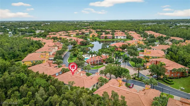 an aerial view of residential houses with outdoor space and trees