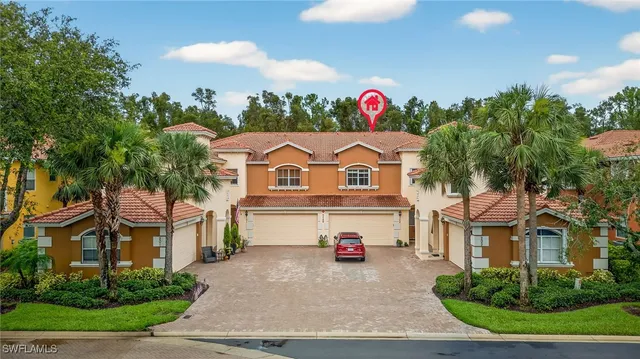 a view of a white house with a white fence and a yard