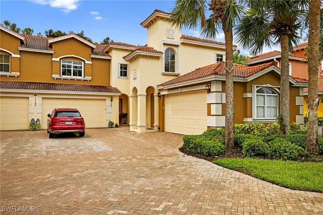 a view of a white house with a large windows and a yard
