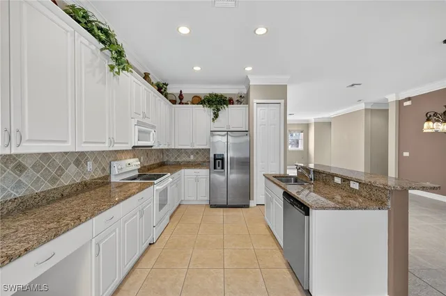 a large kitchen with granite countertop a sink and cabinets