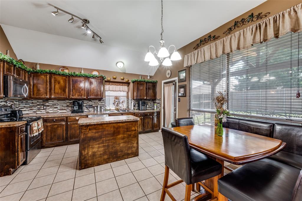 305 Ravenna Road Lake Dallas, TX 75065 - Photo 7 of 23 a kitchen with stainless steel appliances granite countertop a sink a stove and chairs