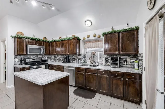 a kitchen with a sink a stove top oven and cabinets