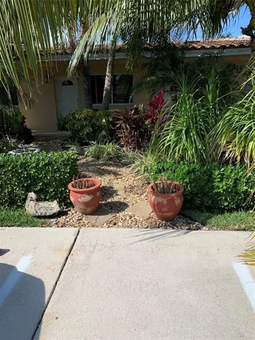 a view of a backyard with plants and patio