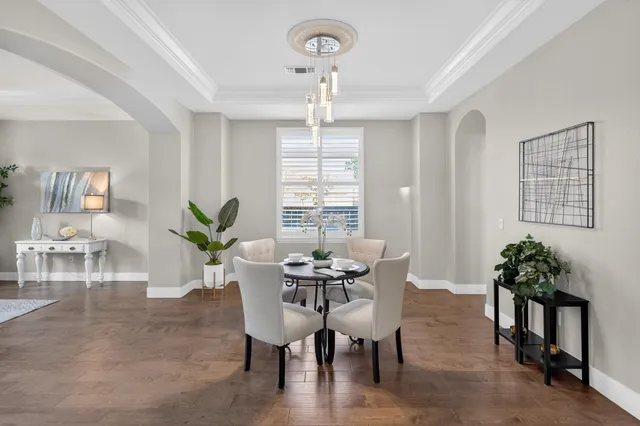 a kitchen with stainless steel appliances granite countertop a kitchen island a stove a refrigerator a sink a dining table and chairs