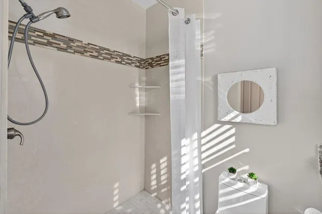a bathroom with a granite countertop sink a mirror and a shower