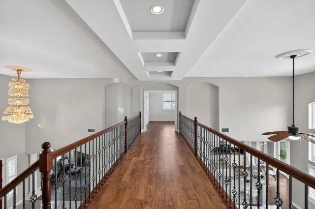 a view of a room with wooden floor and ceiling fan