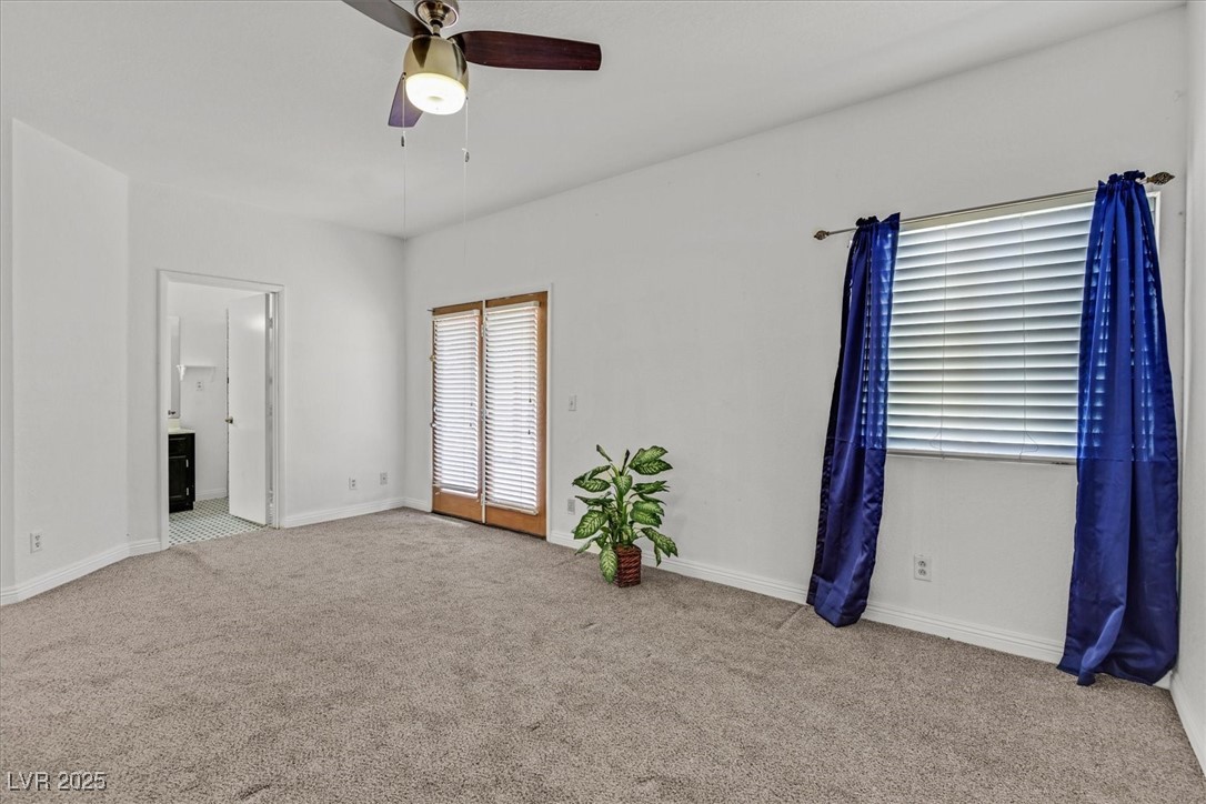 731 Rising Star Drive Henderson, NV 89014 - Photo 14 of 25 Unfurnished bedroom with carpet floors, connected bathroom, baseboards, and a ceiling fan