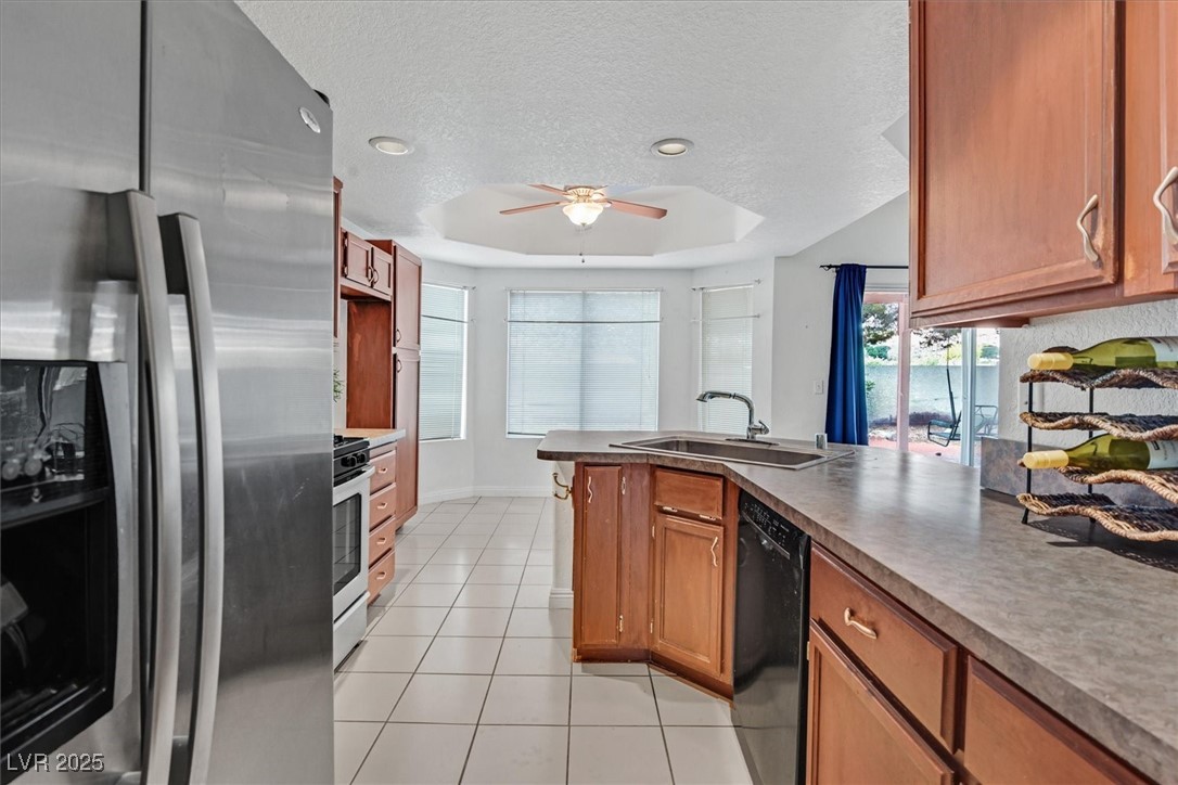 731 Rising Star Drive Henderson, NV 89014 - Photo 10 of 25 Kitchen featuring stainless steel refrigerator with ice dispenser, a sink, black dishwasher, ceiling fan, and gas range
