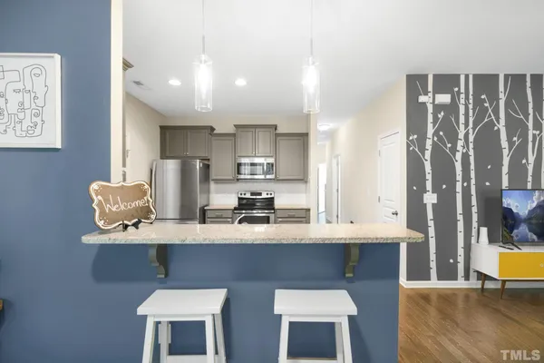 a dining table with chairs and kitchen view
