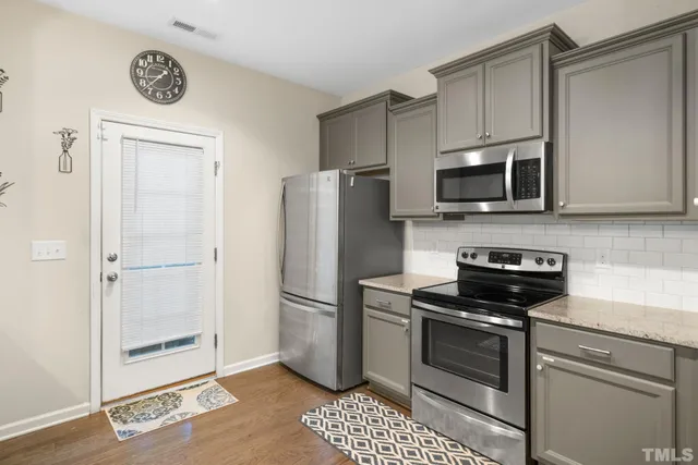 a kitchen with granite countertop a refrigerator stove and microwave