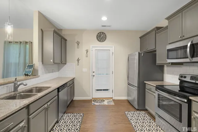 a kitchen with stainless steel appliances granite countertop a sink stove and refrigerator
