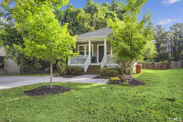 a view of a house with a yard and tree s