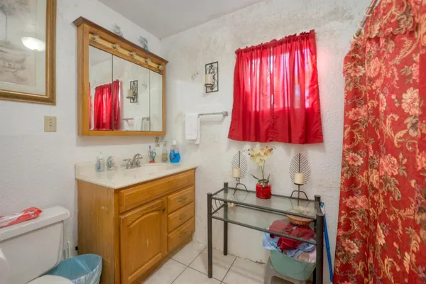 a bedroom with a bed and a large mirror on the dresser