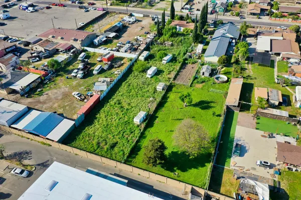 an aerial view of residential houses with outdoor space and trees
