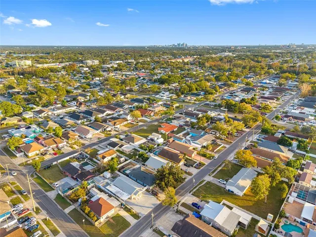 an aerial view of residential houses with outdoor space and trees