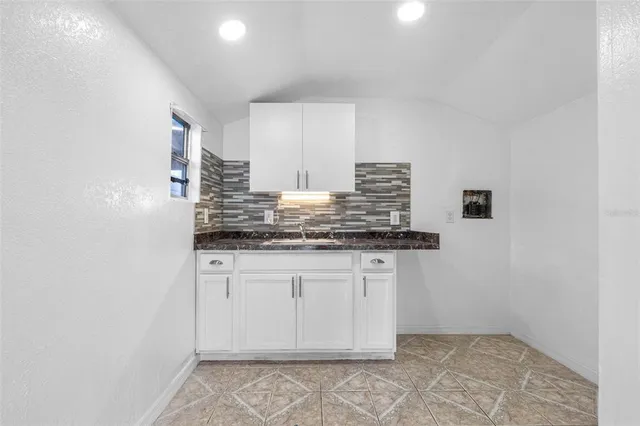 a kitchen with stainless steel appliances a sink a microwave a refrigerator and cabinets