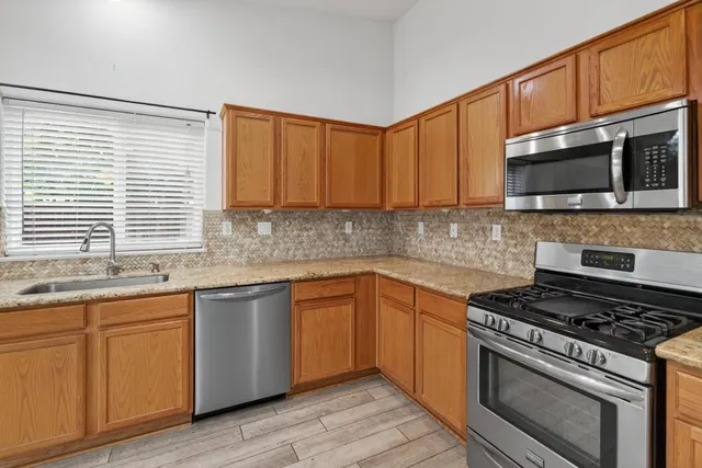 a kitchen with stainless steel appliances granite countertop a stove sink microwave and cabinets