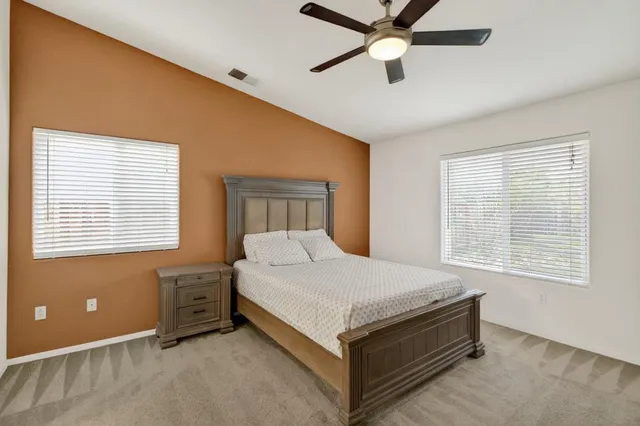 a bedroom with a bed and a ceiling fan