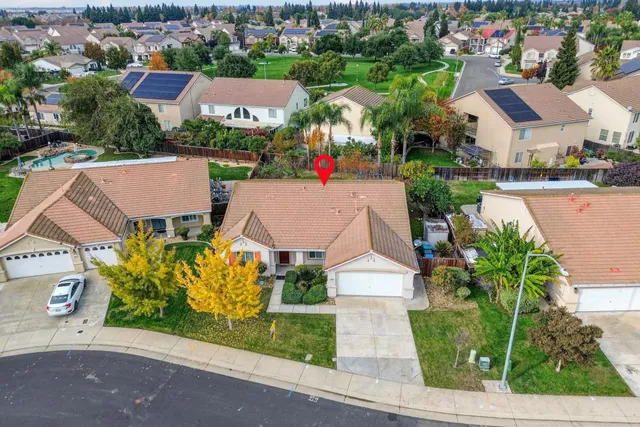 an aerial view of residential houses with outdoor space and parking