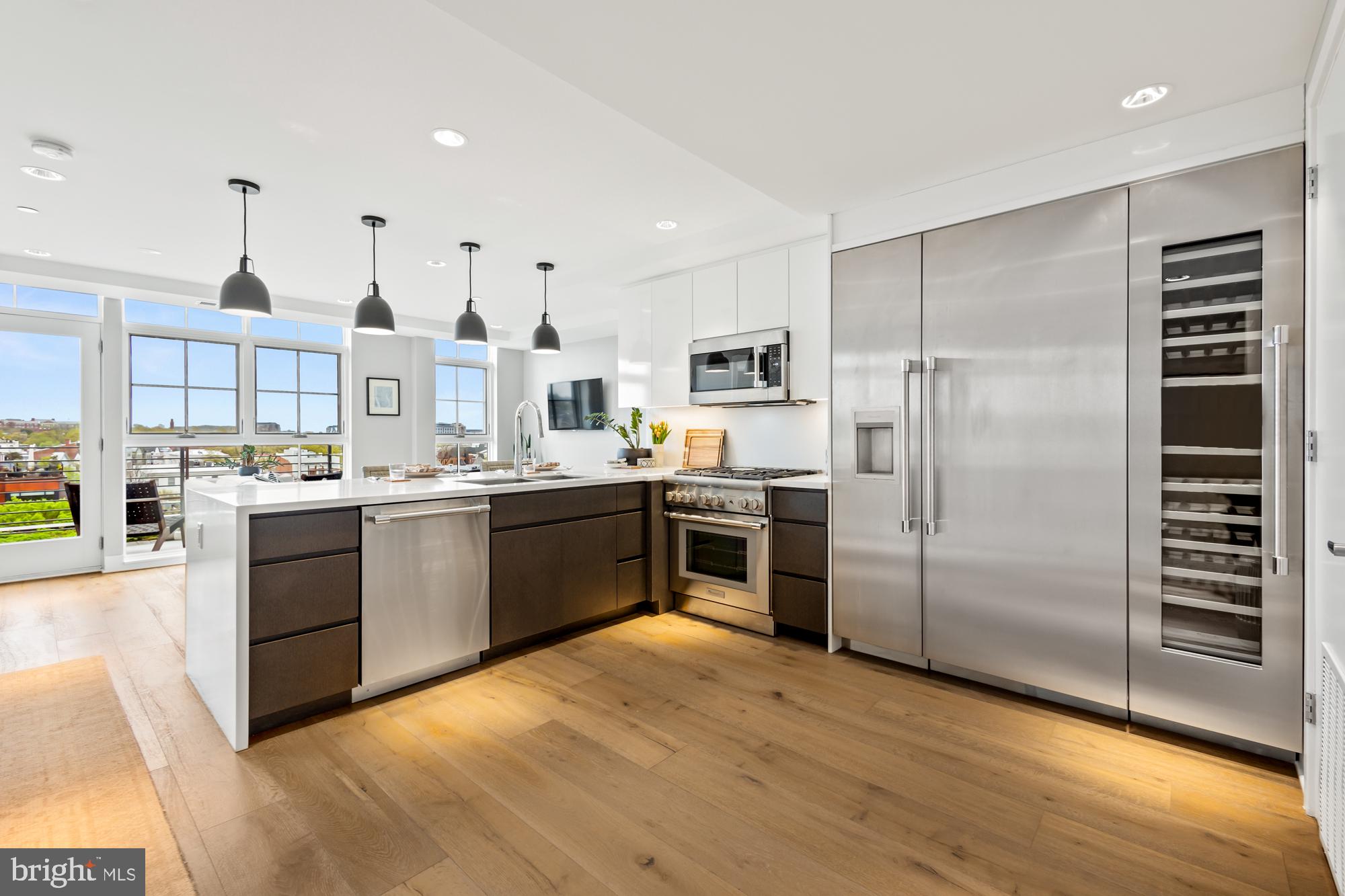 a kitchen with stainless steel appliances kitchen island a refrigerator sink and cabinets