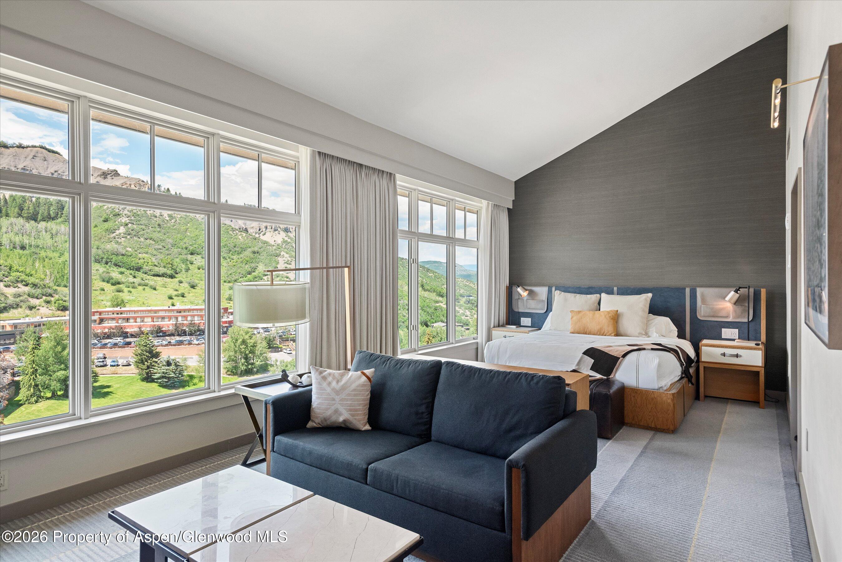 130 Wood Road, Unit 701/801 Snowmass Village, CO 81615 - Photo 17 of 41 a bedroom with a bed couch and a large window