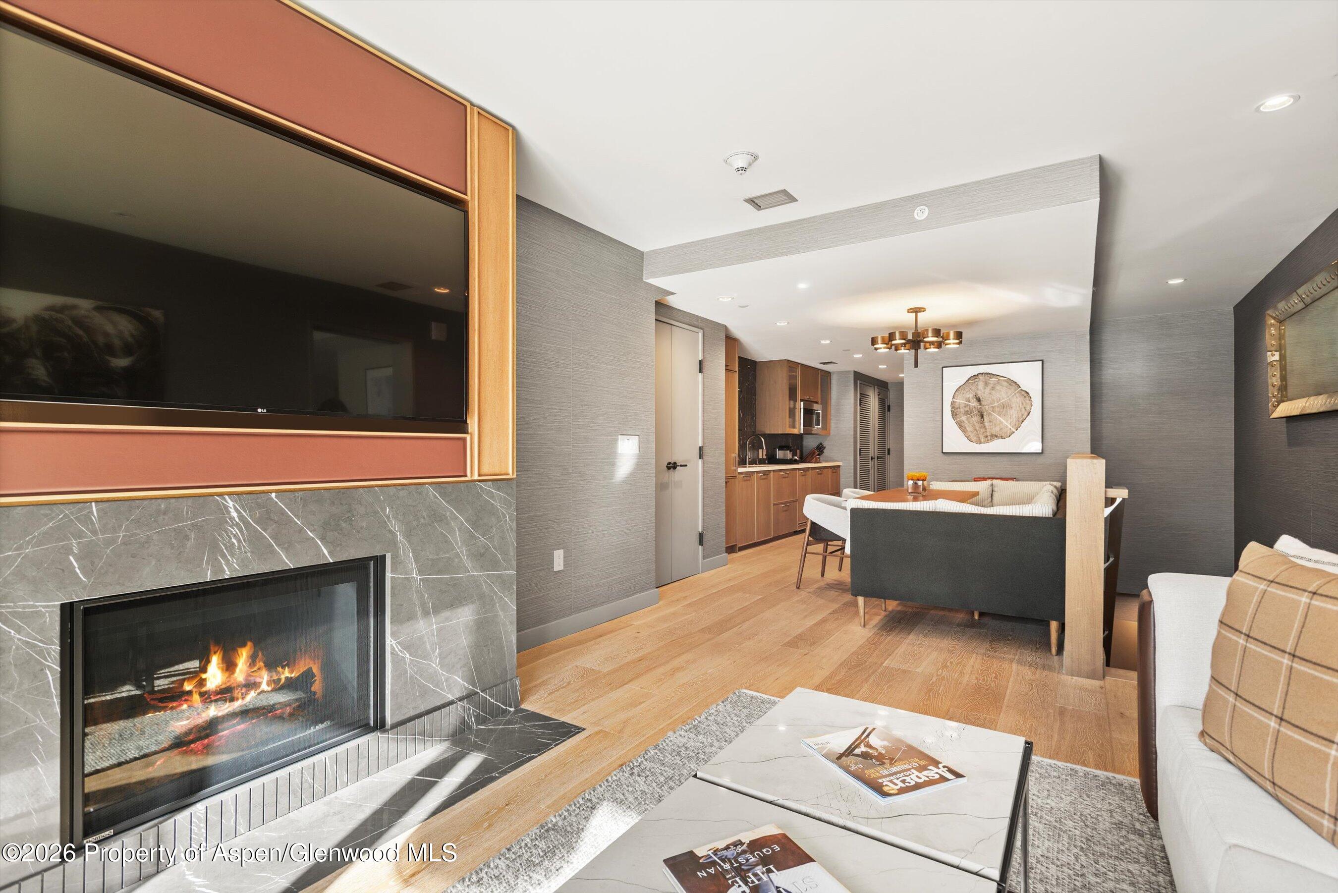 130 Wood Road, Unit 701/801 Snowmass Village, CO 81615 - Photo 26 of 41 a living room with furniture a flat screen tv and a fireplace