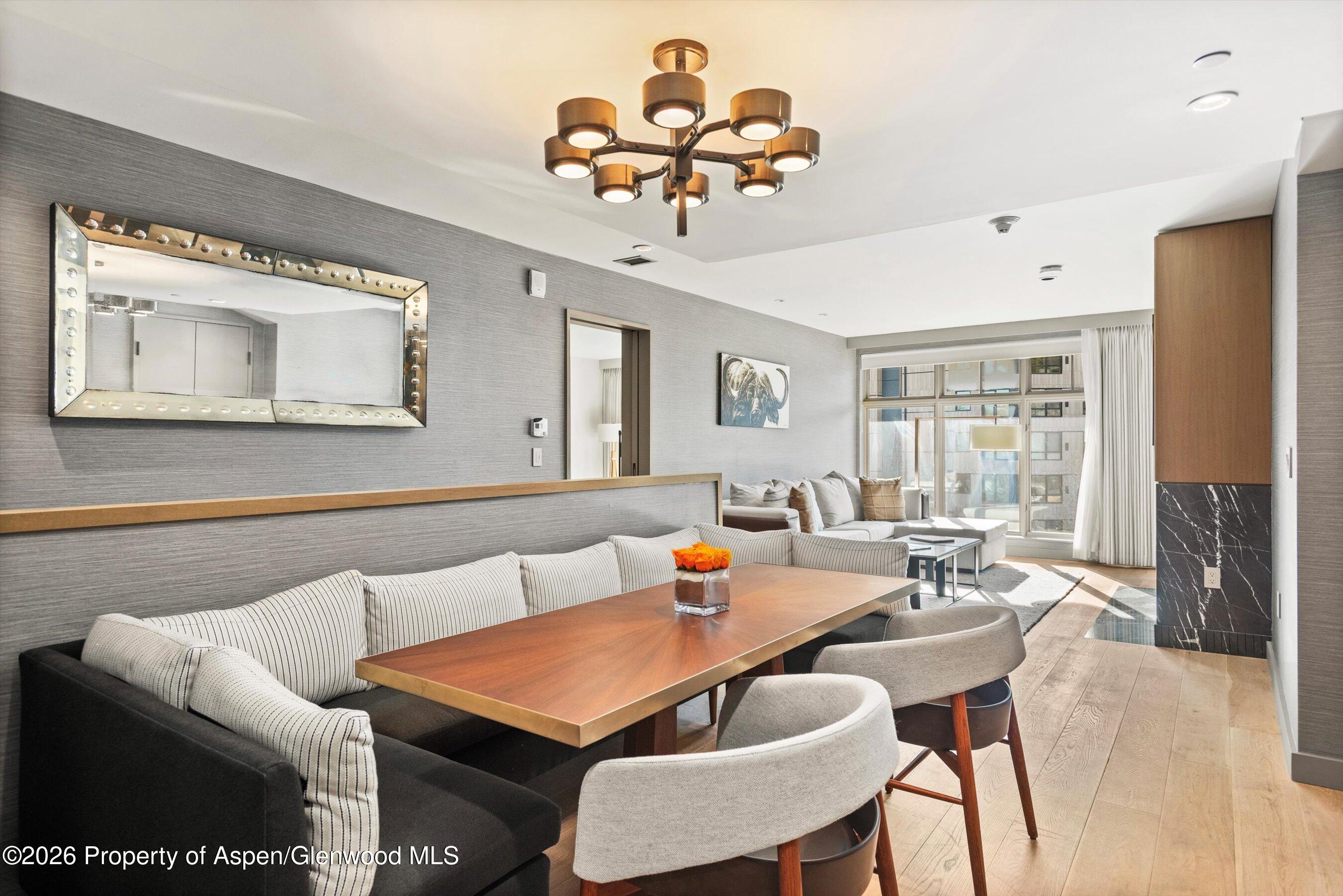 130 Wood Road, Unit 701/801 Snowmass Village, CO 81615 - Photo 28 of 41 a living room with furniture a chandelier and a flat screen tv
