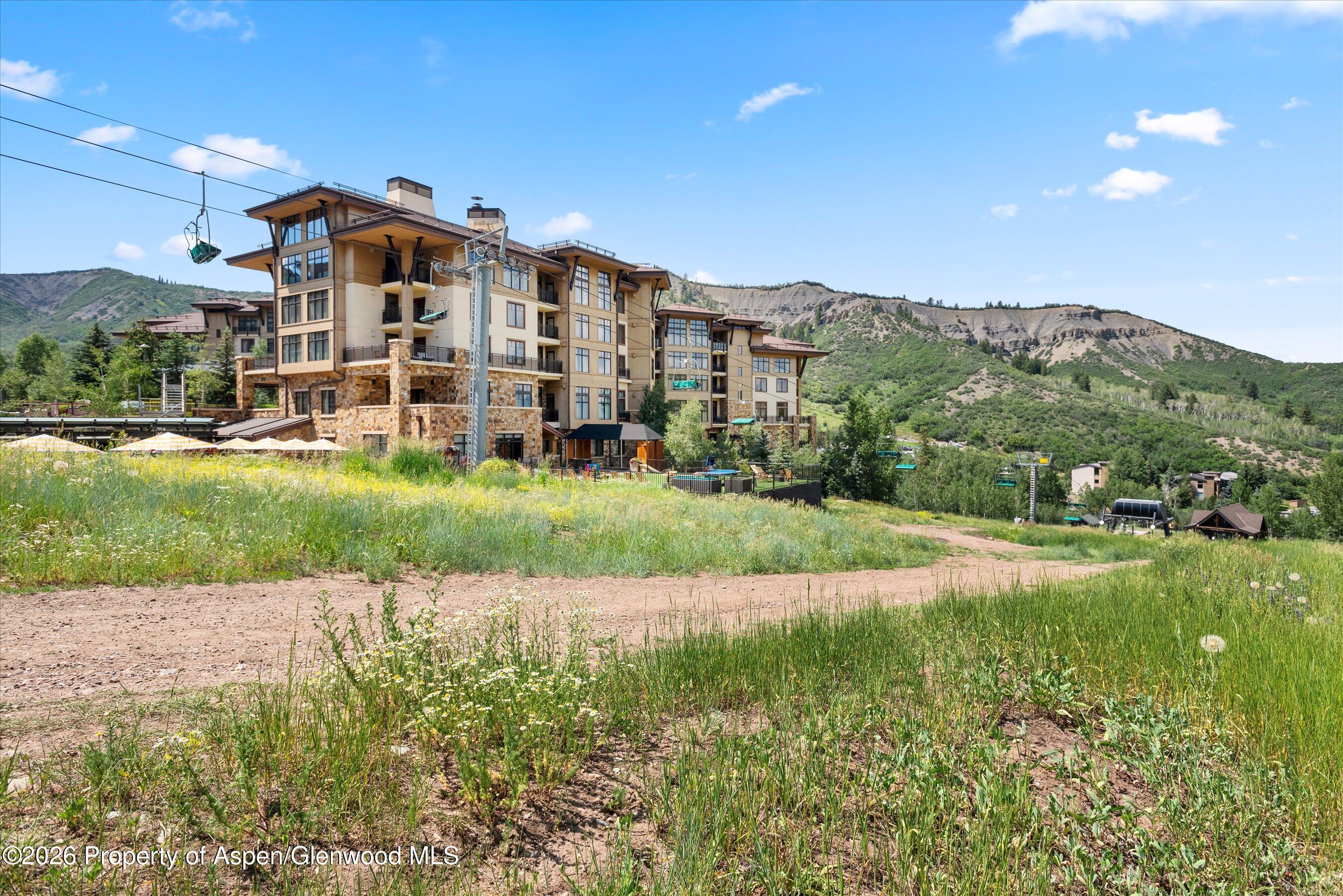 130 Wood Road, Unit 701/801 Snowmass Village, CO 81615 - Photo 36 of 41 a view of a big building with a big yard and large trees
