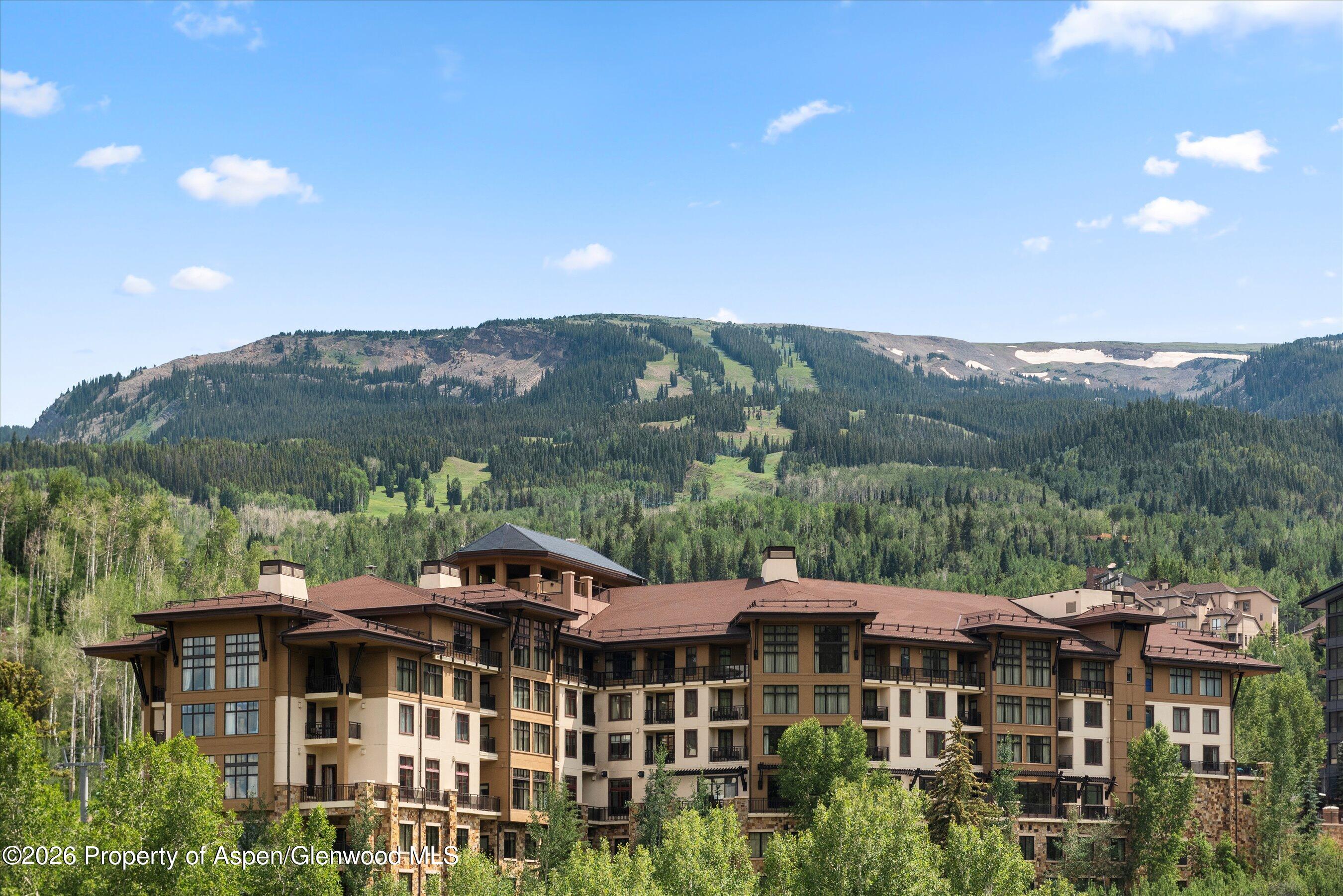 130 Wood Road, Unit 701/801 Snowmass Village, CO 81615 - Photo 39 of 41 a front view of residential houses with a yard and mountain view