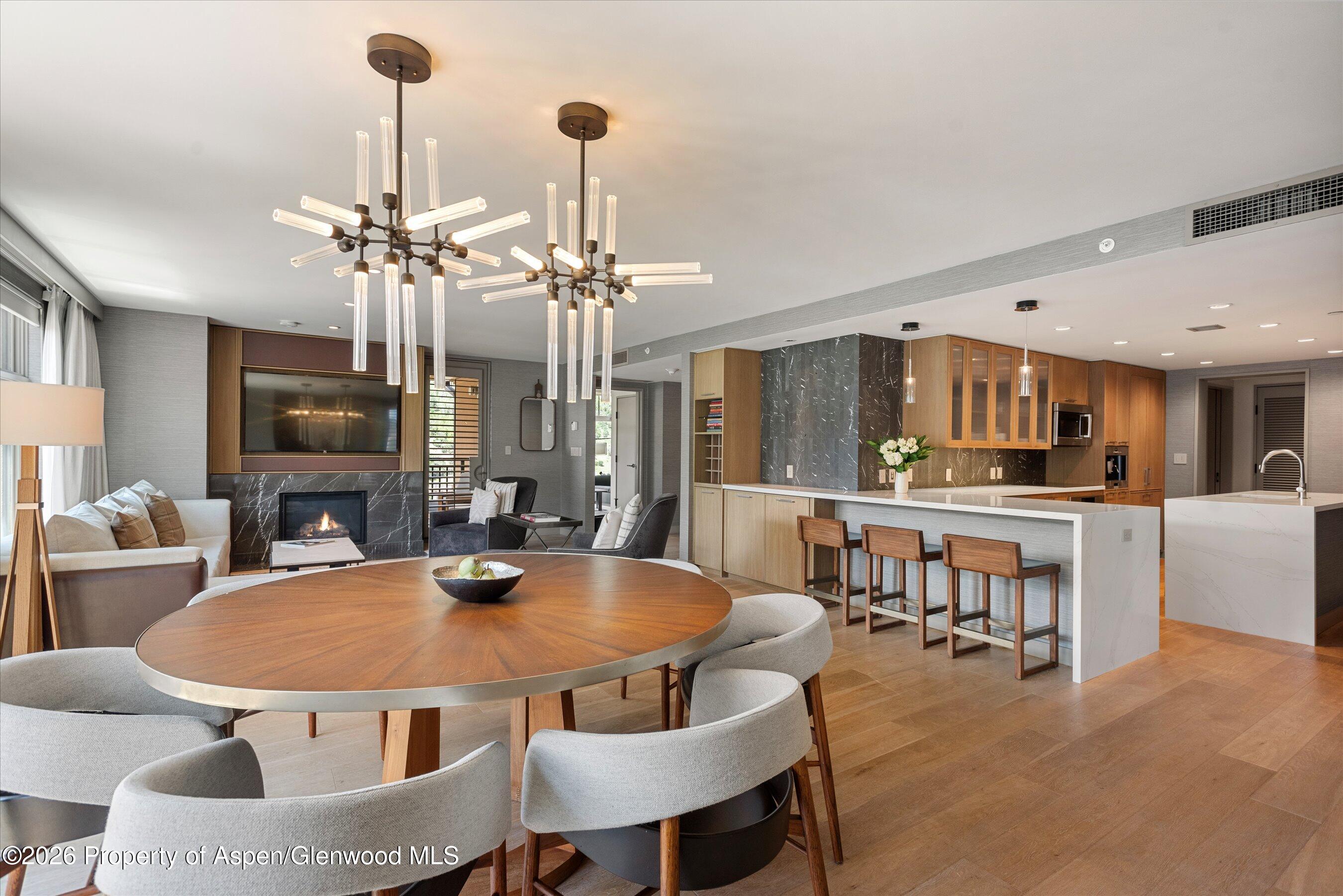 130 Wood Road, Unit 701/801 Snowmass Village, CO 81615 - Photo 7 of 41 a dining room with furniture a chandelier and kitchen view