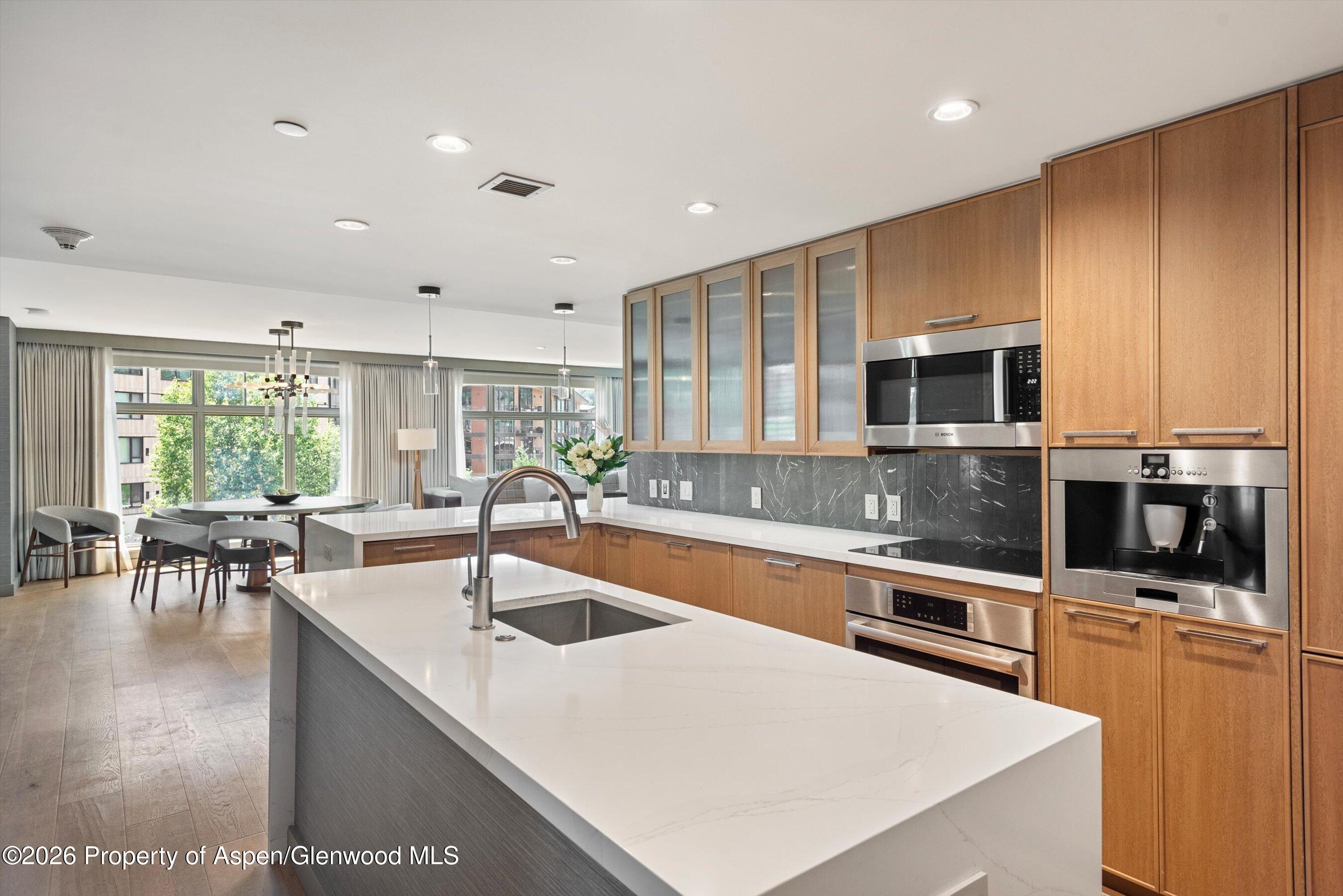 130 Wood Road, Unit 701/801 Snowmass Village, CO 81615 - Photo 10 of 41 a kitchen with stainless steel appliances granite countertop a sink a stove top oven a counter space and cabinets