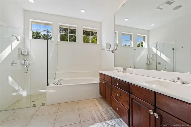 a spacious bathroom with a tub sink and mirror