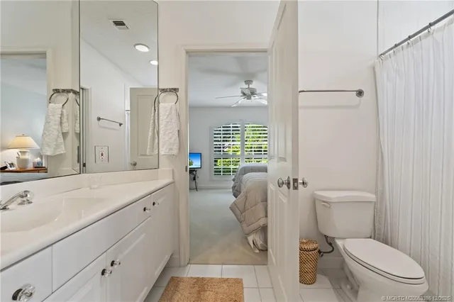 a bathroom with a sink a toilet a mirror and shower