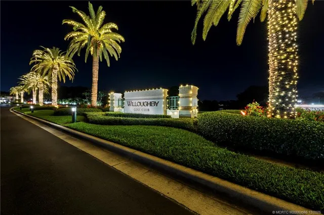 a front view of a house with a garden and trees