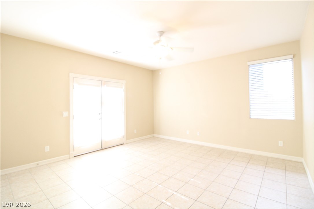 754 Rise Canyon Drive Henderson, NV 89052 - Photo 22 of 34 Natural light bathes this spacious room, featuring elegant tile flooring and convenient exterior access.
