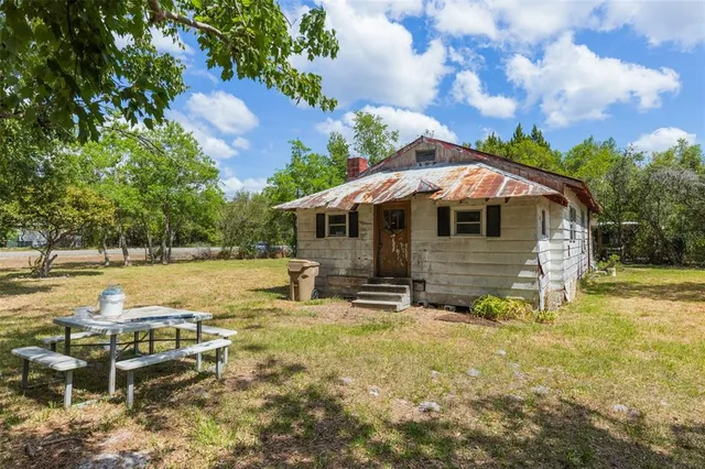 a view of a house with backyard and sitting area
