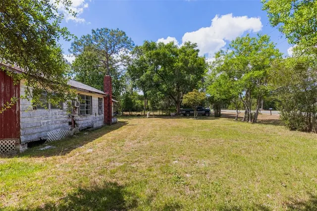 a view of a house with backyard and sitting area