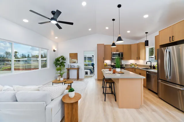 a living room with kitchen island furniture and a view of kitchen