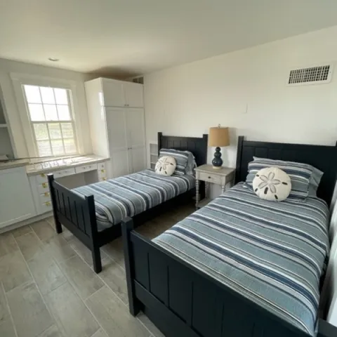 a bedroom with two beds and a window