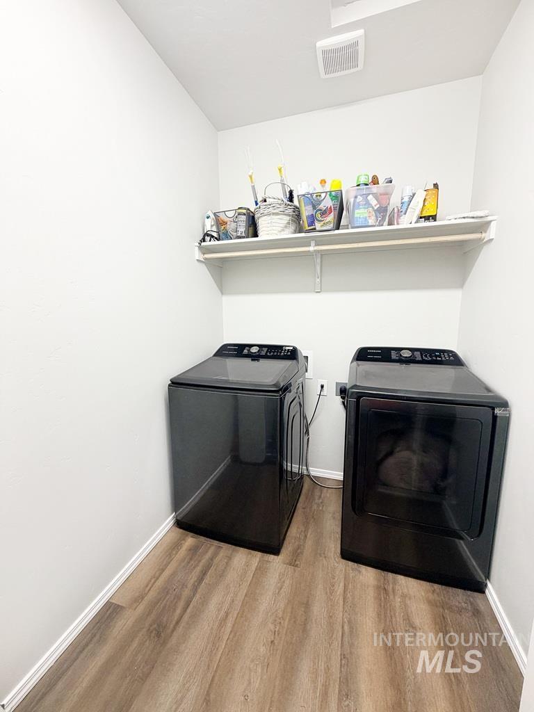 13694 Oliver Street Caldwell, ID 83607 - Photo 13 of 28 Laundry room with washing machine and clothes dryer and light wood finished floors
