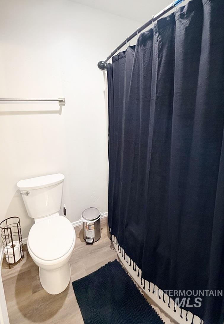 13694 Oliver Street Caldwell, ID 83607 - Photo 16 of 28 Full bath featuring curtained shower and wood finished floors
