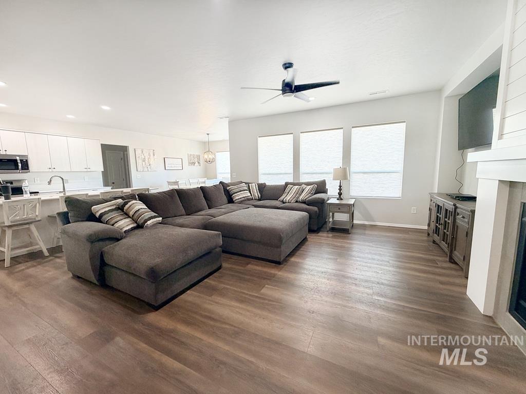 13694 Oliver Street Caldwell, ID 83607 - Photo 5 of 28 Living area with dark wood-type flooring, a ceiling fan, recessed lighting, and a glass covered fireplace
