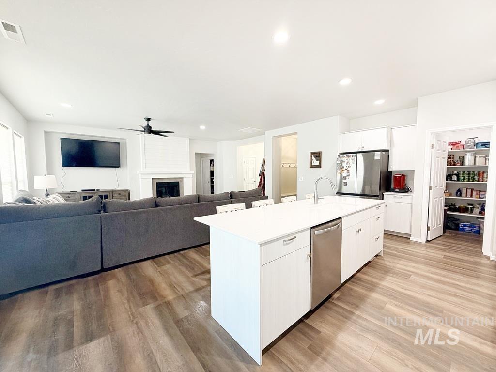 13694 Oliver Street Caldwell, ID 83607 - Photo 9 of 28 Kitchen with white cabinets, stainless steel appliances, light wood finished floors, ceiling fan, and recessed lighting