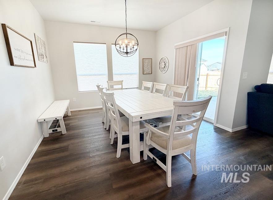 13694 Oliver Street Caldwell, ID 83607 - Photo 10 of 28 Dining space featuring dark wood-style flooring and hanging lights