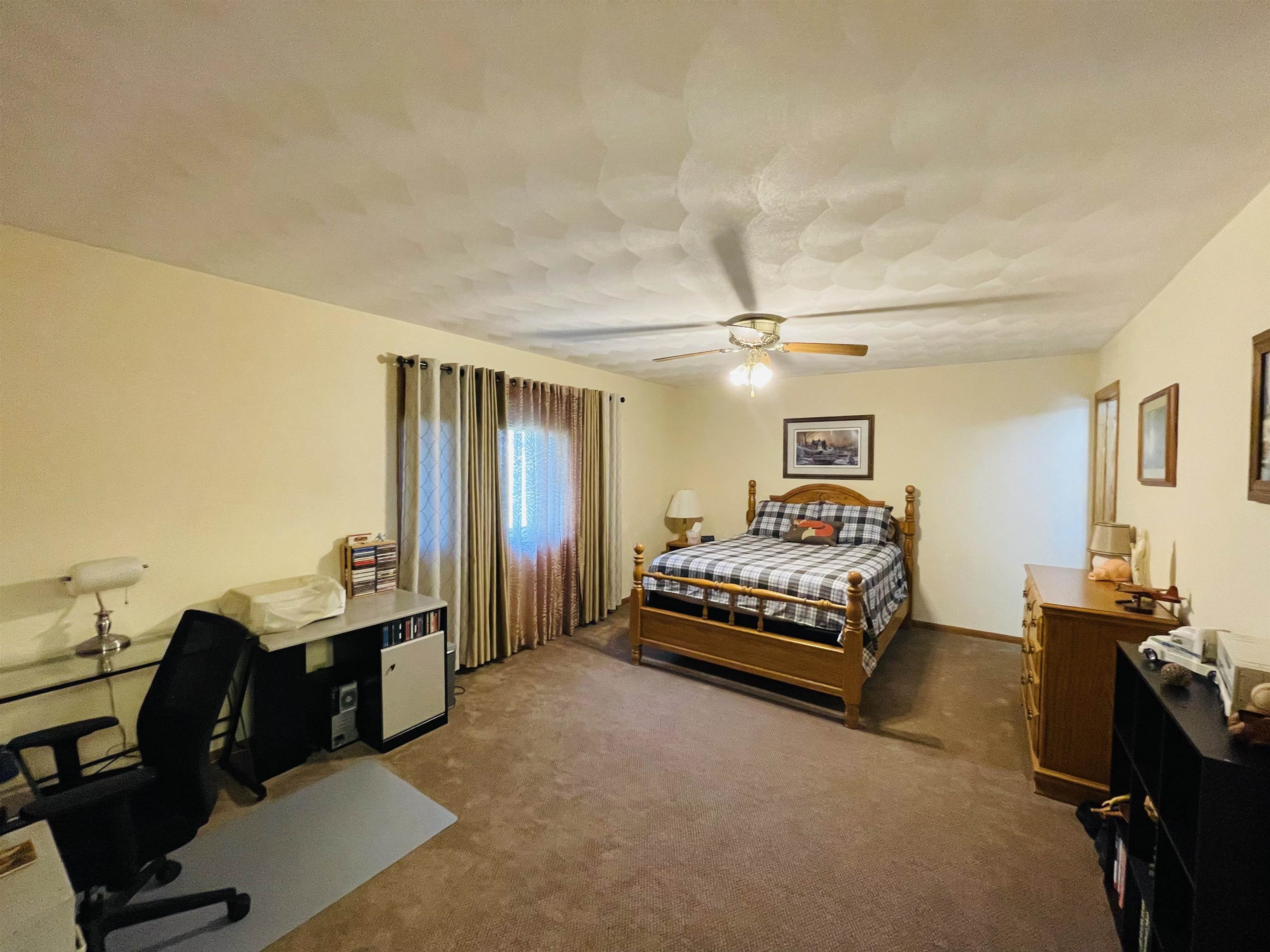 1292 South Trainer Road Rockford, IL 61108 - Photo 7 of 17 a bedroom with furniture and a large window
