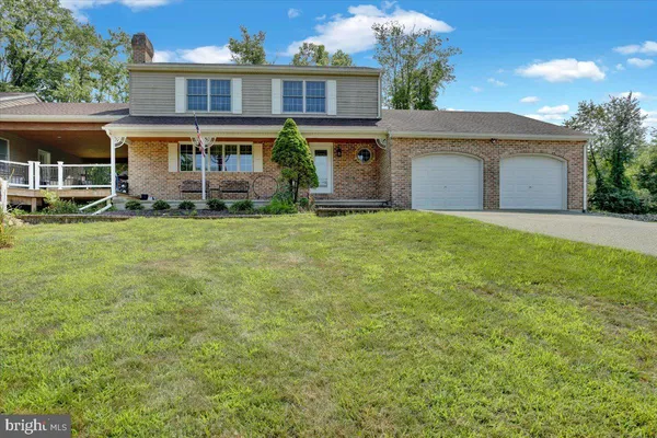 a front view of a house with a garden and yard