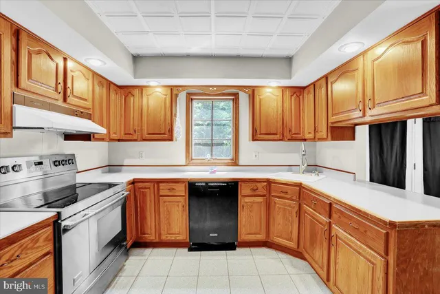 a kitchen with stainless steel appliances granite countertop a sink counter space cabinets and a large window