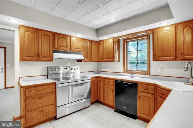 a kitchen with stainless steel appliances granite countertop a sink stove and cabinets